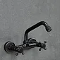 Baterie de perete din alama, culoare neagra, cu gura ridicata la un unghi de 115 grade, inaltime 19 cm